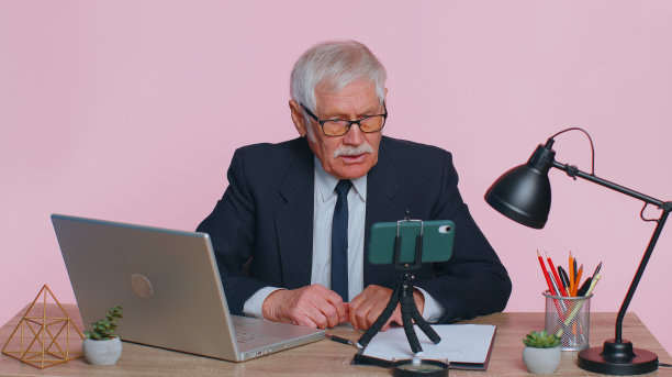 资深商人做手机会议视频咨询、呼叫中心座席、话务员图片下载