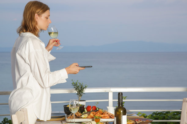 一名女子在餐厅用餐前用智能手机拍下食物图片下载