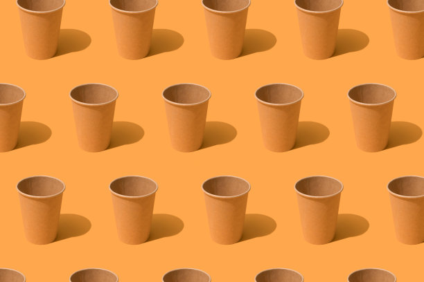 图案与生态纸一次性咖啡杯在橙色的背景，模型的形象。可持续食品包装理念图片下载