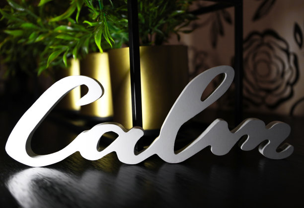 房子的内部装饰，在一件家具或瓷砖上用白色的“CALM”字样。图片下载