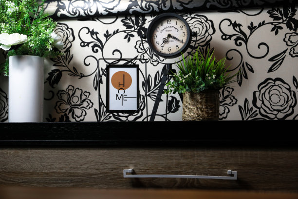 一所房子的室内装饰，在一幅画中有“家”字，旁边有一个钟和一株植物。图片下载