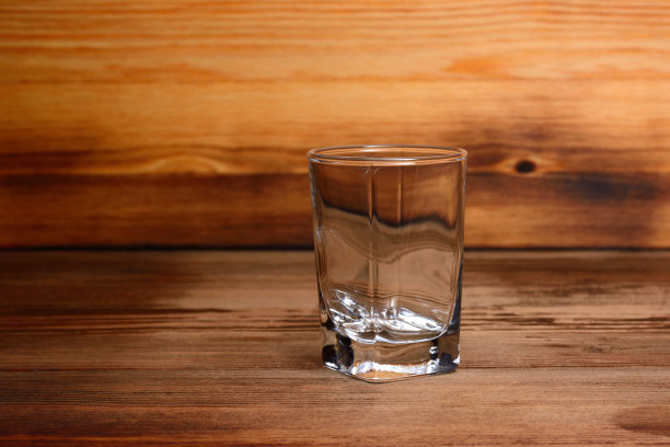 木制背景上的空玻璃杯堆叠特写图片下载