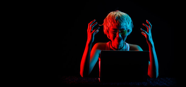 金发女子在笔记本电脑交易加密货币股票盈利，玩在线游戏的乐趣图片下载