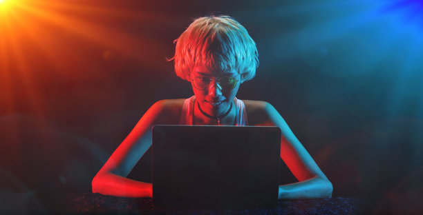 金发女子在笔记本电脑交易加密货币股票盈利，玩在线游戏的乐趣图片下载