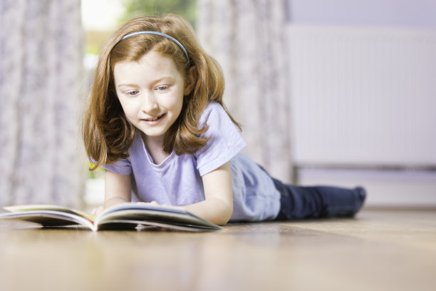 七岁的女孩在休息室看书图片下载