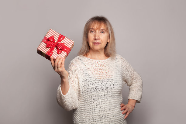 可爱的老妇人拿着白色背景的礼物图片下载