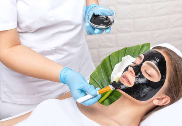 美容师在美容院为美丽的蓝眼睛女孩做脱碳手术。硬件美容治疗。图片下载