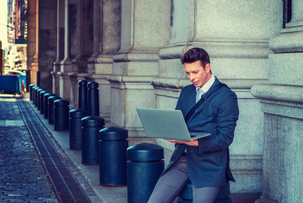 在纽约街头用笔记本电脑工作的年轻人图片下载