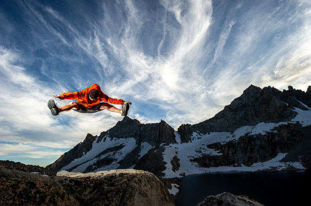 在雪山顶上庆祝成功的越野跑者图片下载