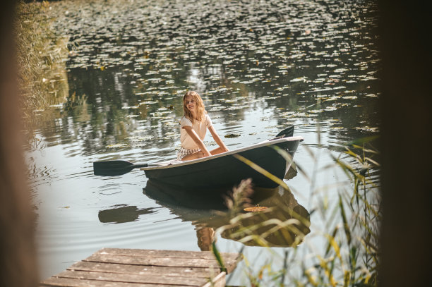 快乐的白人女士划船沿河图片下载