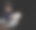 光脚的棕发小男孩坐在地板上和他的狮子狗狗在工作室里玩，淡杏色。水平，黑色背景，复制空间图片下载