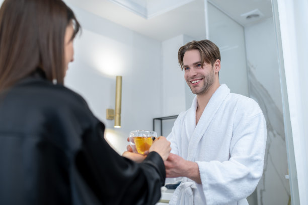 在一家温泉沙龙，一位女服务员正在给客人倒茶图片下载