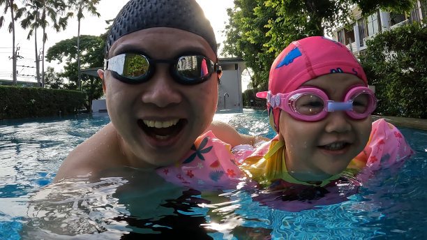 一个亚洲女孩在游泳池里游泳图片下载