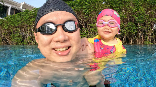 一个亚洲女孩在游泳池里游泳图片下载