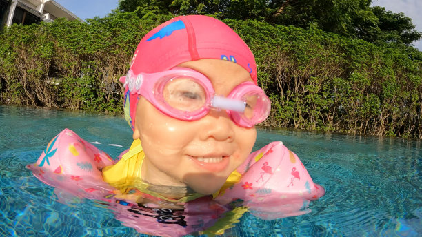 一个亚洲女孩在游泳池里游泳图片下载