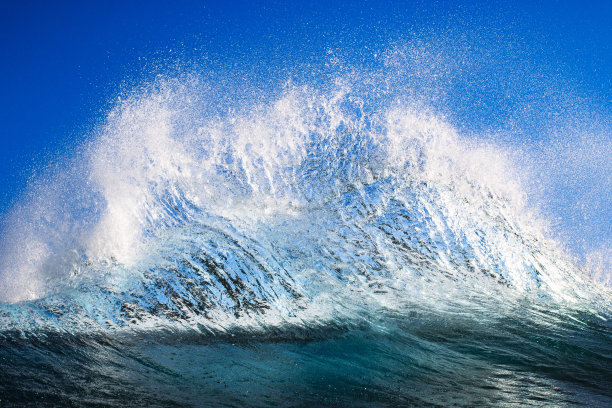 明亮的蓝色波浪在晴朗的天空下创造抽象的水图案图片下载