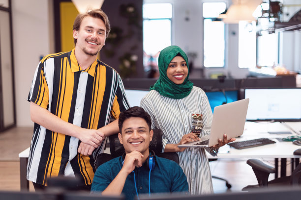 不同种族的创业团队在现代开放式办公室内开会，使用笔记本电脑和台式电脑集思广益。焦点选择图片下载