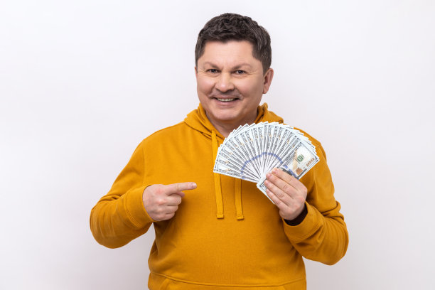 富翁用手指着大钞迷，为中了彩票而欣喜。图片下载