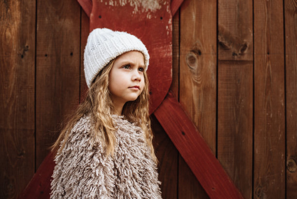 时尚的四岁长发女孩在木制背景上摆姿势。幸福宝宝的肖像。时尚照片。文本。图片下载