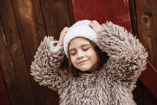 时尚的四岁长发女孩在木制背景上摆姿势。一个漂亮婴儿的肖像。时尚的孩子。文本的地方图片下载