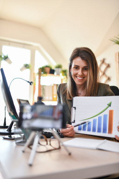 微笑的女性在办公室解释图表时做视频博客图片下载