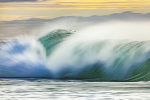 长曝光照片平滑的海浪打破点燃了柔和的早晨的太阳图片下载