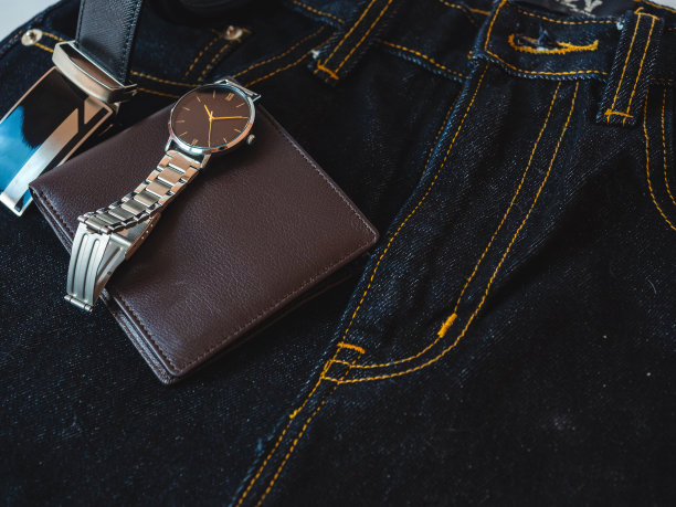棕色皮革钱包上的牛仔裤背景。图片下载