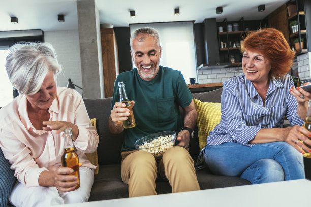 一群年长的朋友周末在家一起吃爆米花、喝啤酒、看电视图片下载