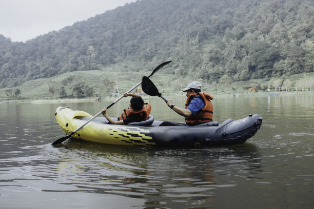 小男孩和他的父亲喜欢在湖上划皮艇图片下载