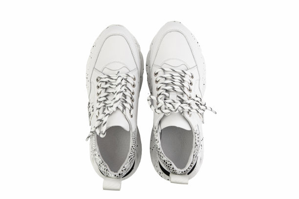 白色皮革运动鞋。休闲女性的风格。白色花边和白色橡胶鞋底。孤立的特写白底。前视图。时尚的鞋子图片下载