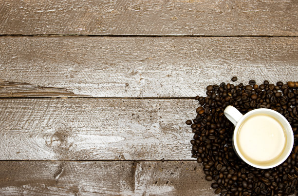牛奶咖啡杯与烤豆在木桌子上图片下载
