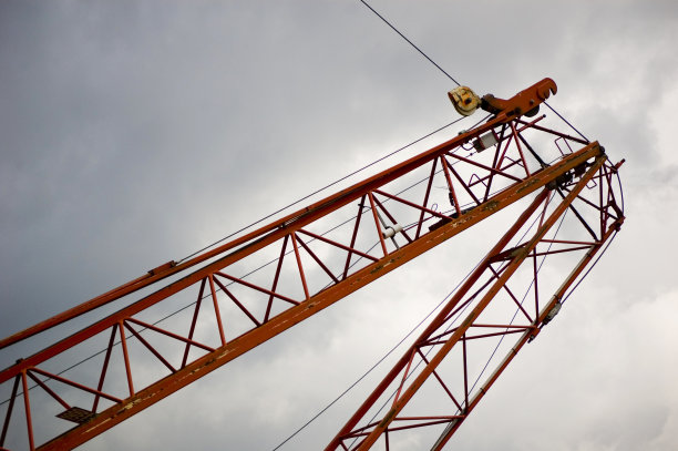 在建筑物上工作的大型工地起重机。图片下载