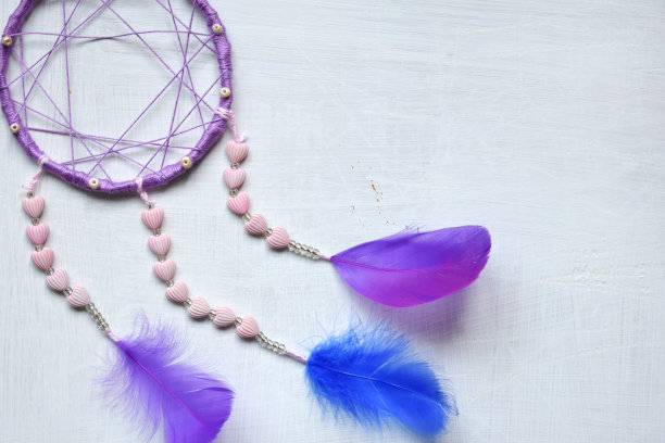 白色背景的紫色捕梦网。捕梦网卧室装饰配件，特写照片。工作坊、爱好、手工艺、创意理念。图片下载