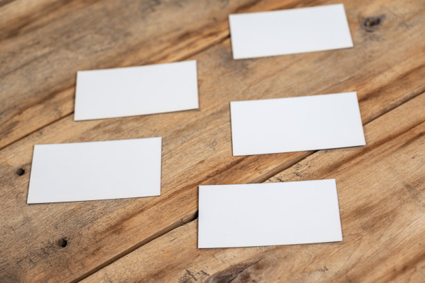 木制背景的空白名片。五个长方形的白纸放在有裂缝的旧木板上。有选择性的重点。图片下载