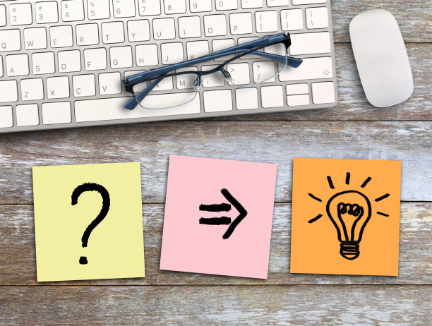 问号和灯泡写在彩色便签在木桌子的背景。图片下载