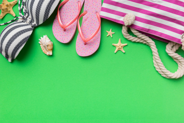 女子泳装和海滩配件平铺顶视彩色背景夏季旅行的概念。比基尼泳装，草帽和高跟鞋。复制空间俯视图图片下载