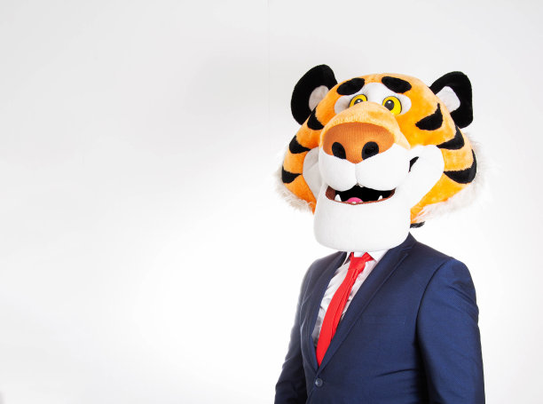 一个穿着西装的男人，头上戴着有趣的老虎面具，背景是白色的。复制空间的文本，幽默图片下载