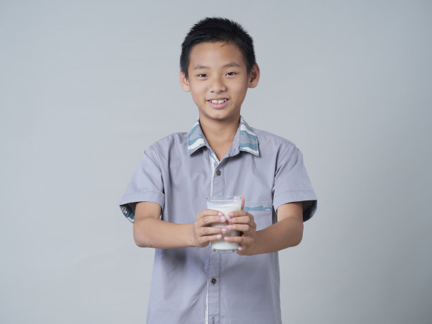 灰色背景的小男孩在喝牛奶图片下载