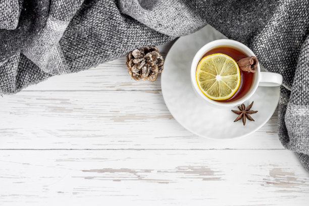 一杯加了柠檬和肉桂的茶，白色木质背景图片下载