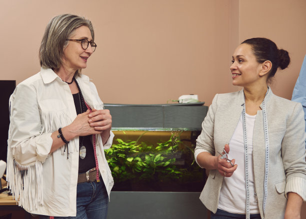 多民族女裁缝团队在时装设计工作室讨论服装新款图片下载