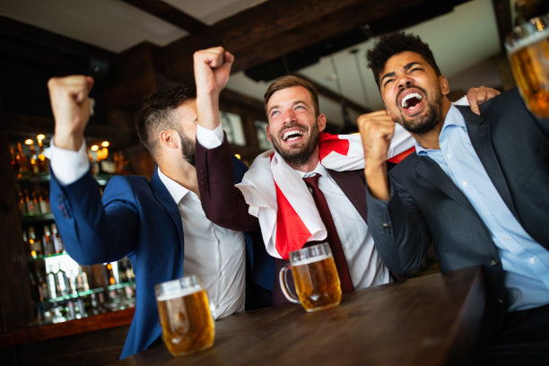 男球迷一边看电视一边尖叫一边在酒吧里喝啤酒图片下载