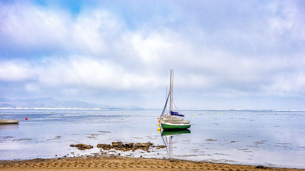 在西班牙穆尔西亚的马尔梅诺浅滩上，一排运动帆船停泊在帆伞旁图片下载