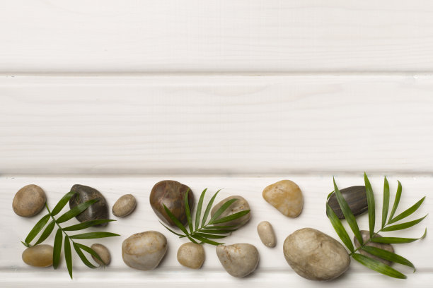 木制背景上的温泉石和树叶，俯视图图片下载