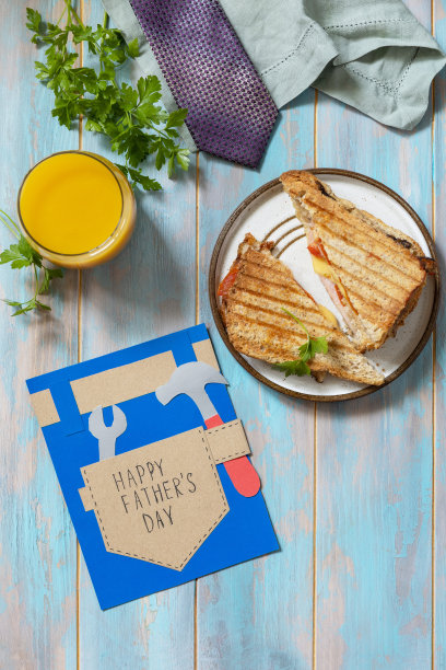 庆祝父亲节。早餐。Fatherâ日卡和木制桌子上的自制培根三明治。从以上观点。图片下载
