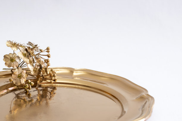 金色的小花放在金色的托盘上图片下载