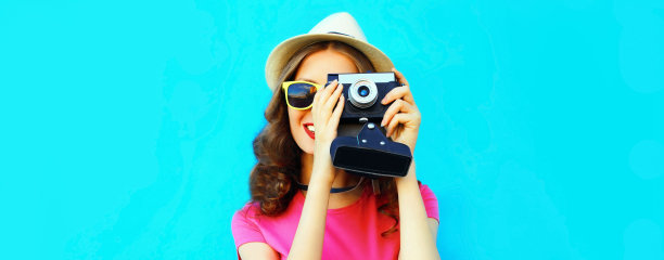 夏季肖像年轻女子摄影师与胶片相机的蓝色背景图片下载