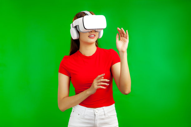 Metaverse照片概念，年轻漂亮的亚洲女人在红色t恤上戴着vr耳机孤立在绿色背景。图片下载