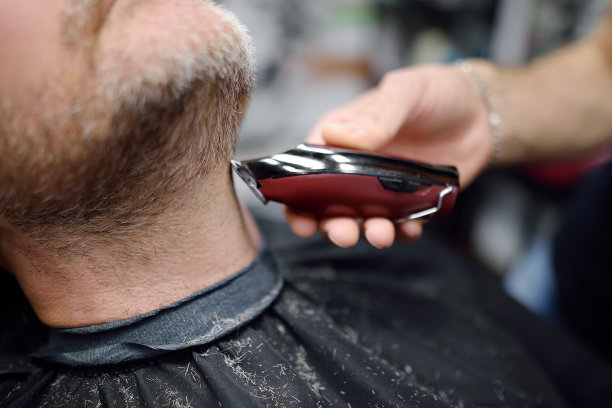 理发师师傅正在沙龙里为帅气成熟的大胡子男子剃须。美发师在理发店为顾客做发型。专业造型师服务。男士时尚护发图片下载