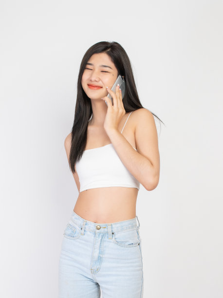 一个拿着手机的年轻亚洲女士的瞬间和表情图片下载