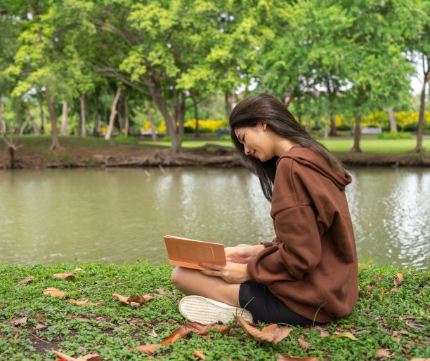 年轻的亚洲女士chill放松和阅读一般的书在公园图片下载
